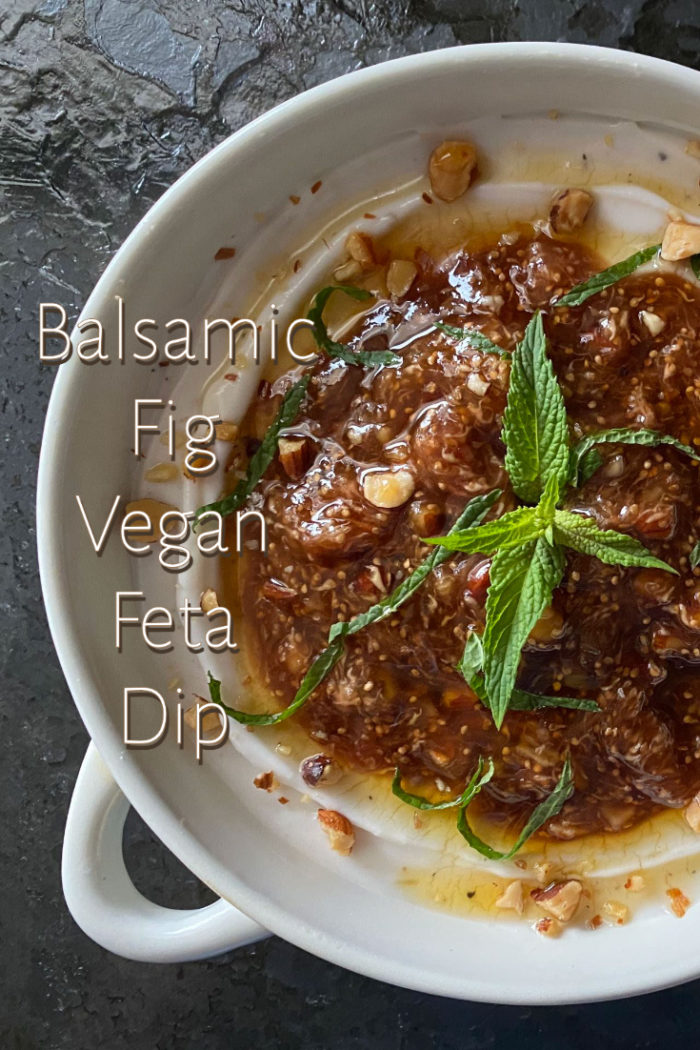 balsamic fig vegan feta dip in a white dish against a black background with white caption