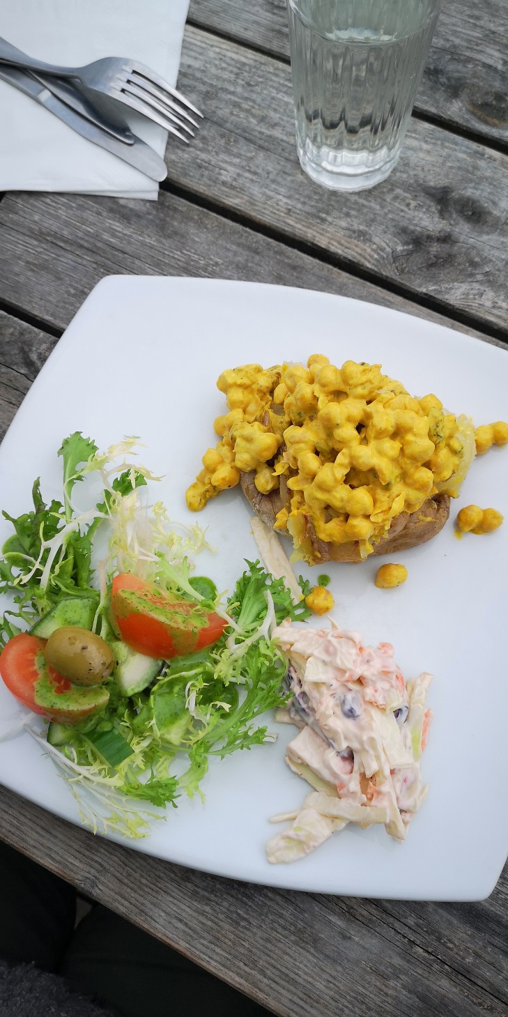 coronation chickpea meal on a white plate on a wooden table top