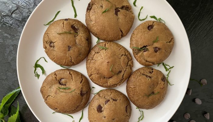 vegan mint chocolate chip cookies on a white plate against a dark background
