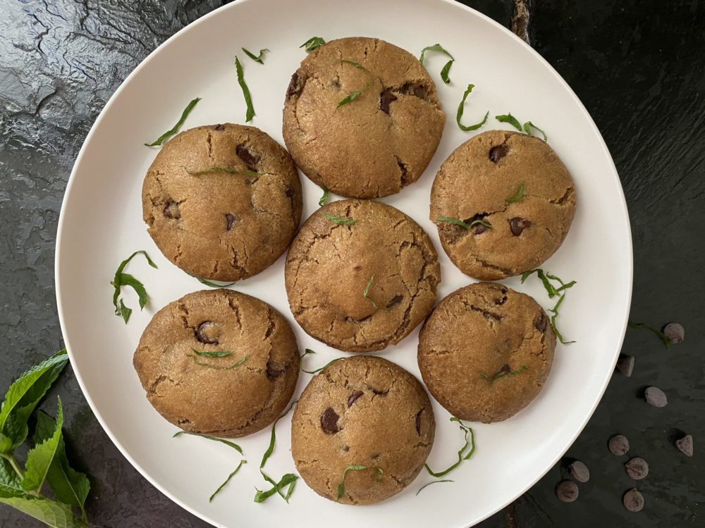 vegan mint chocolate chip cookies on a white plate against a dark background
