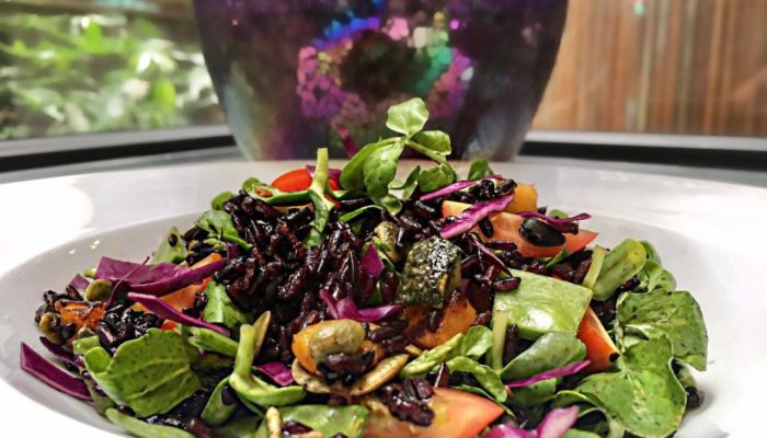 pumpkin and black rice salad with orange dressing in a white bowl