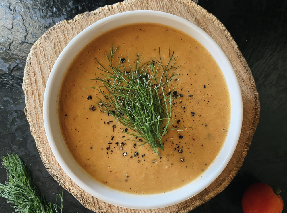 roasted fennel tomato soup in a white bowl against a brown and black background