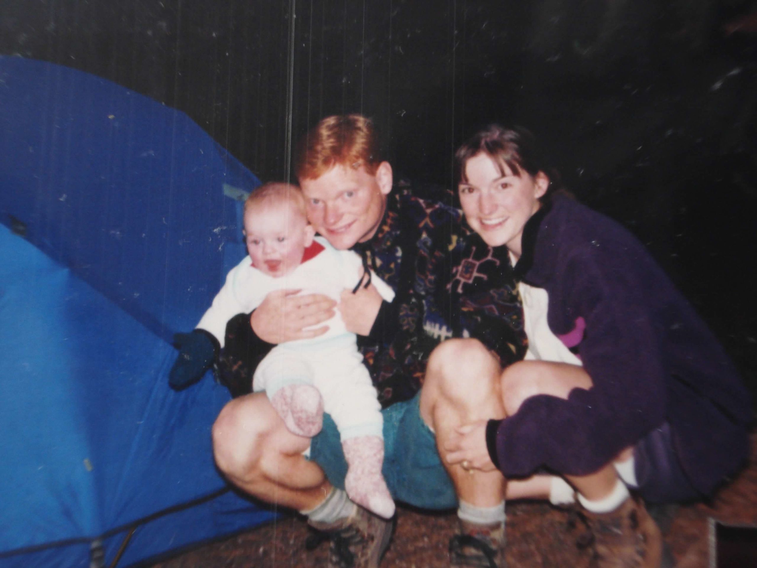 baby and parents in front of tent