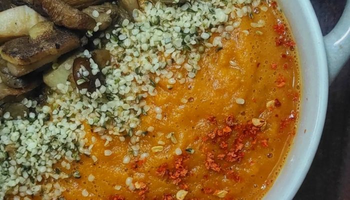 toasted tomato pumpkin soup in a white bowl