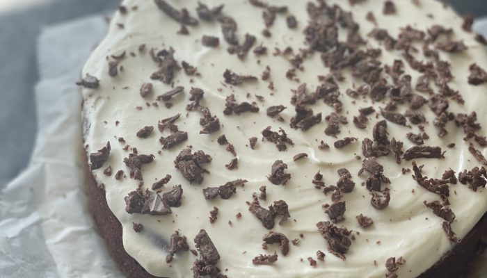 chocolate cake with white frosting on parchment paper