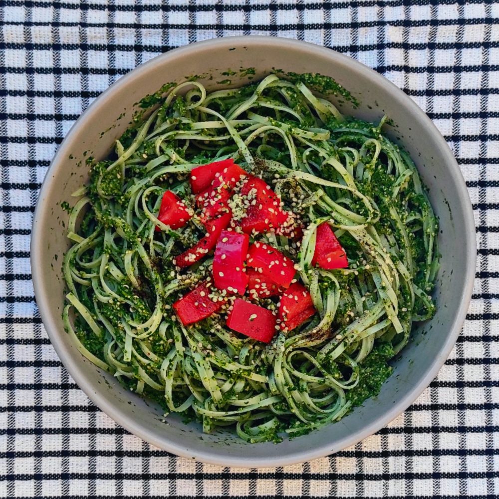 green goddess noodles in a white bowl against a black and white background