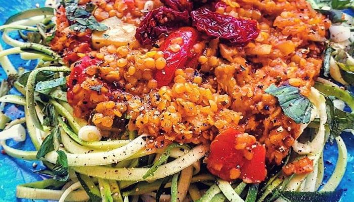 vegan zoodle lentil bolognese on a blue plate