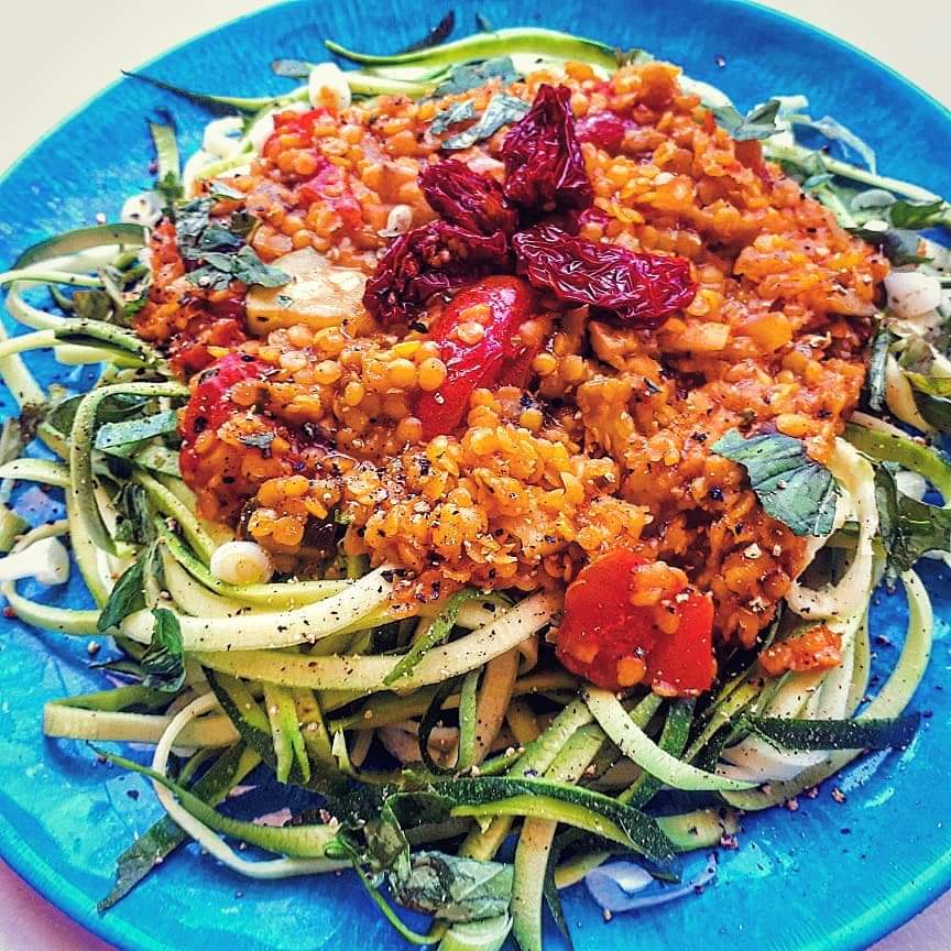 vegan zoodle lentil bolognese on a blue plate