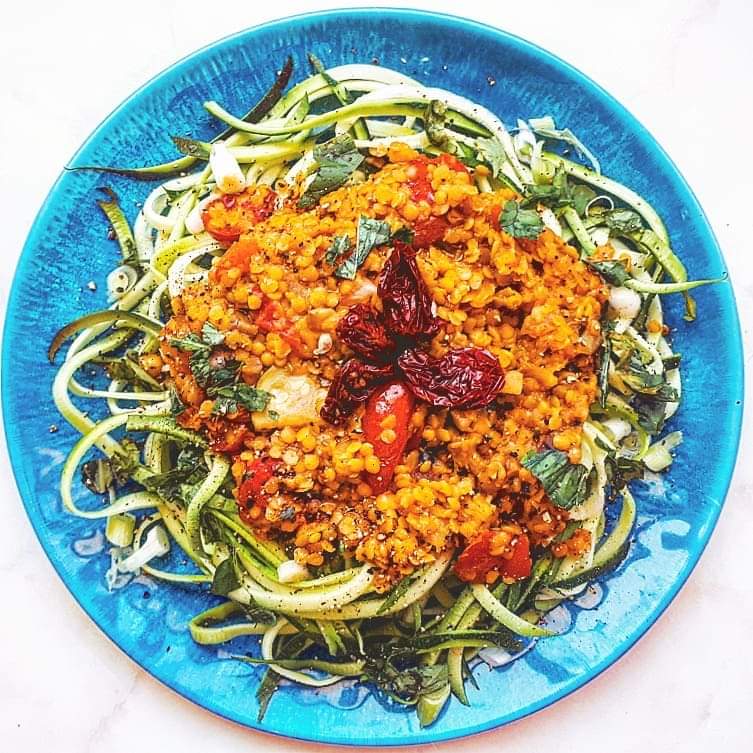 vegan zoodle lentil bolognese on a blue plate
