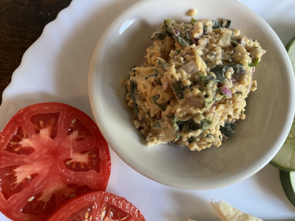 easy vegan crab cake dip in a white dish with tomatoes on the side