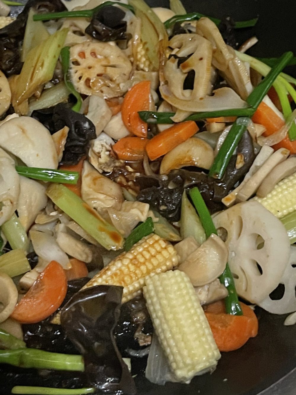 lotus root stir fry with soy sauce in a dark pan