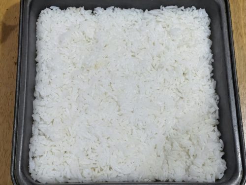 flattened rice in a baking pan