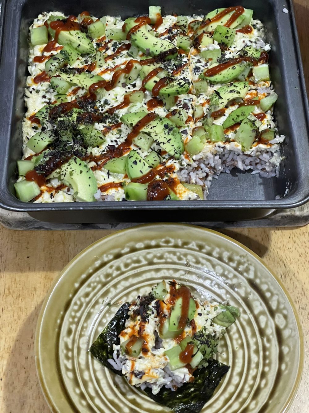 vegan sushi bake in a tray; one serving on a decorative plate