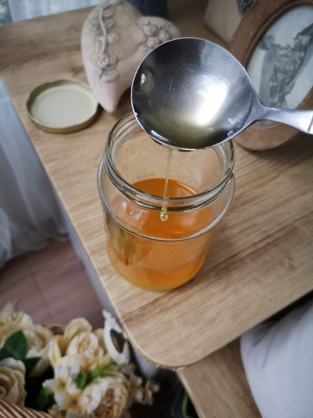 a jar of vegan dandelion honey on a wooden table top
