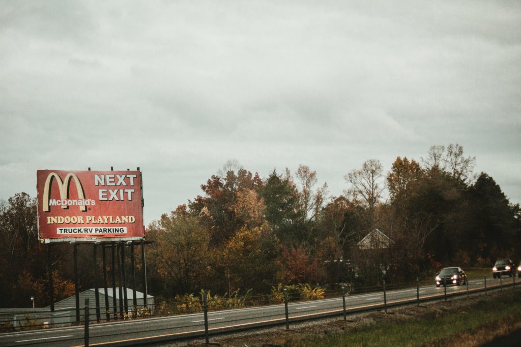 A billboard along the side of a road showing an advertisement for Mcdonalds