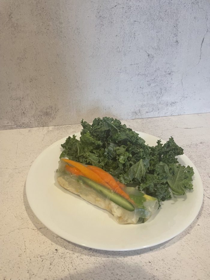 rice paper wrap with kale salad on a white plate