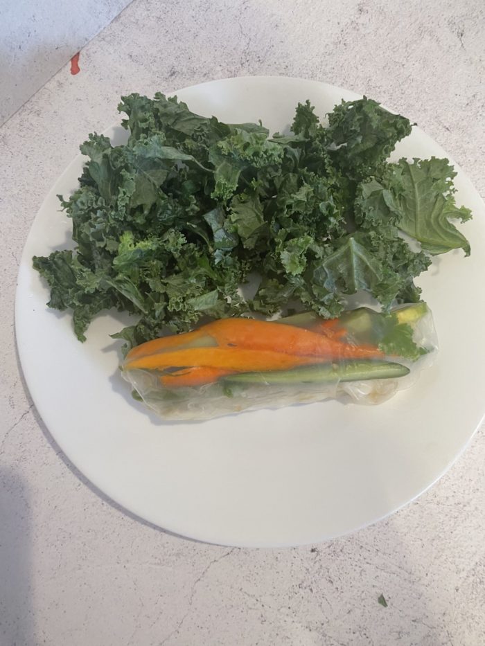 rice paper wrap with kale salad on a white plate
