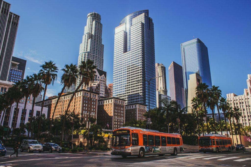 Downtown Los Angeles featuring skyscrapers, the city bus, and palm trees.