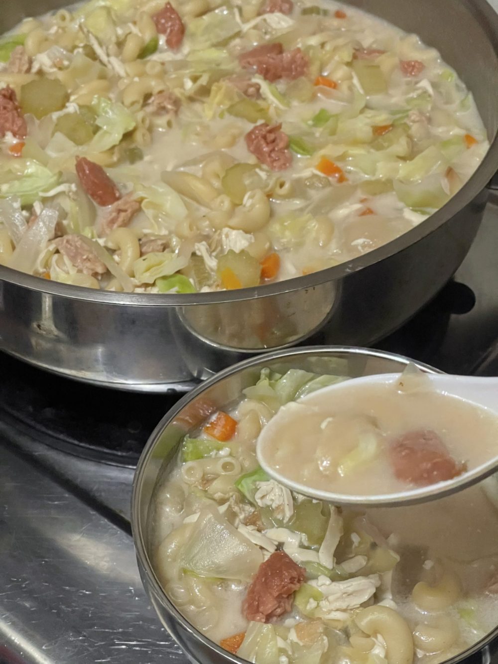 vegan chicken macaroni soup in two silver bowls with a white spoon