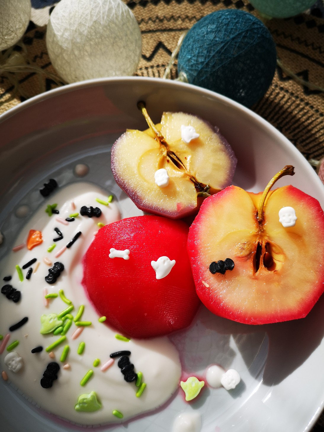 poached apples and sprinkles in a white bowl with decorations in the background