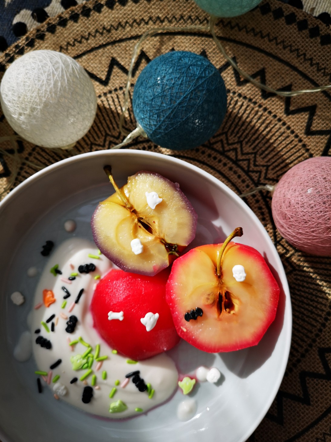 poached apples and sprinkles in a white bowl with decorations in the background