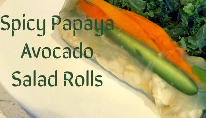 spicy papaya avocado rolls on a plate with dark green caption