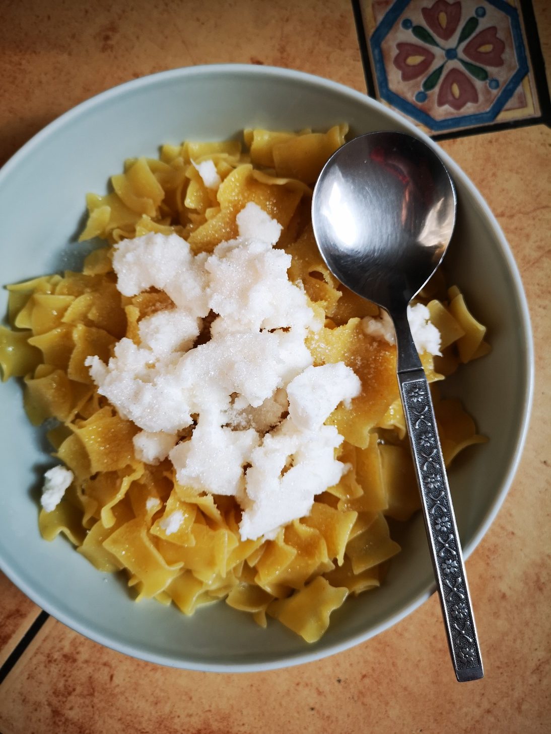 vegan hungarian cottage cheese pasta in a while bowl with a silver spoon