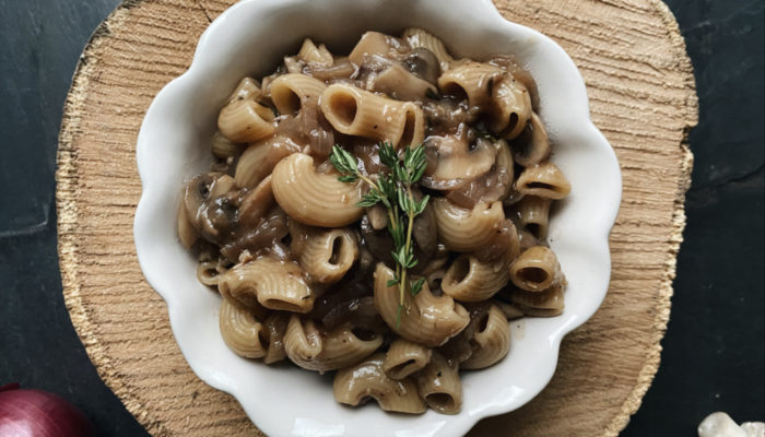 french onion pasta in a white dish against a brown and black background