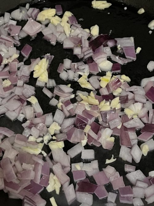 diced onion and garlic in a pan