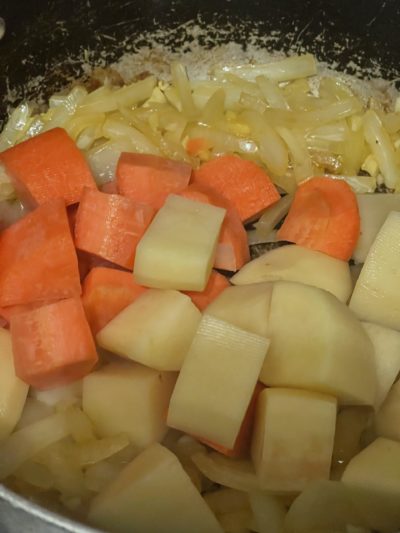 carrots, potatoes, and onions in a pot