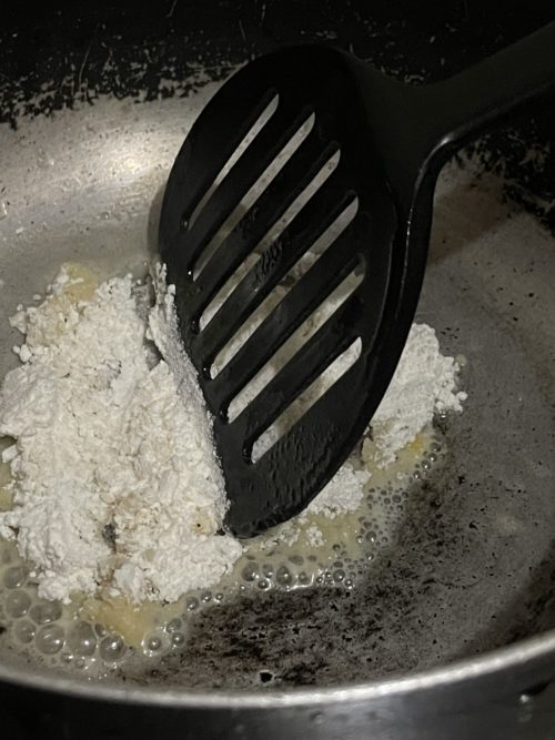 roux in a silver pot with a black spatula