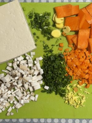 piles of diced vegetables and tofu on a green background