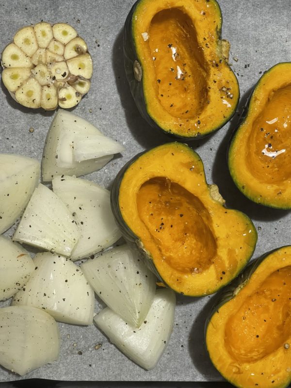 pumpkin miso soup ingredients topped with black pepper on a baking tray