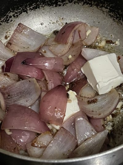 onions and vegan butter in a silver pan