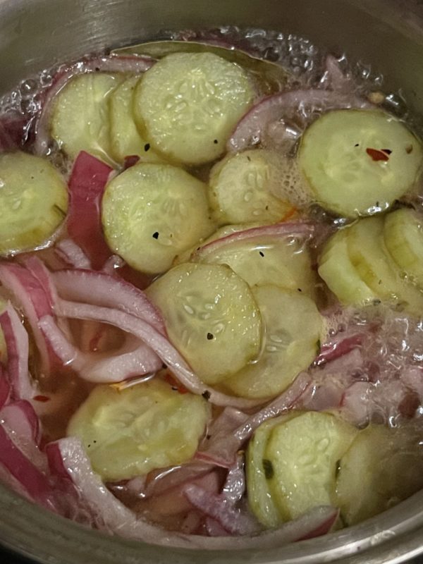 pickles and pickled onions in a silver bowl