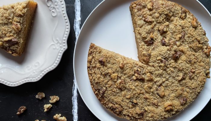 vegan papaya streusel cake on white plates against a dark background