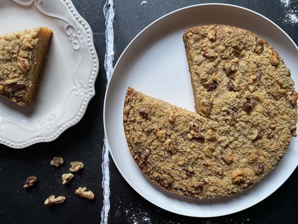 vegan papaya streusel cake on white plates against a dark background