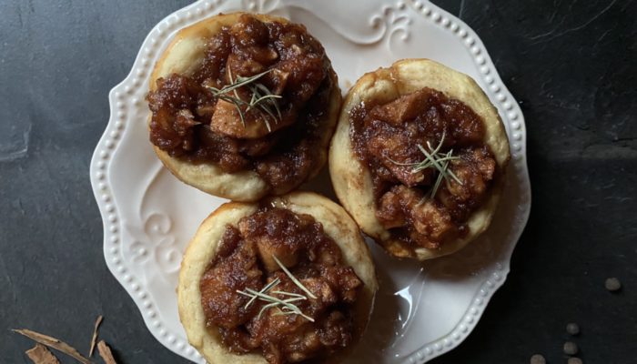 vegan apple cinnamon rolls on a white plate on a black background