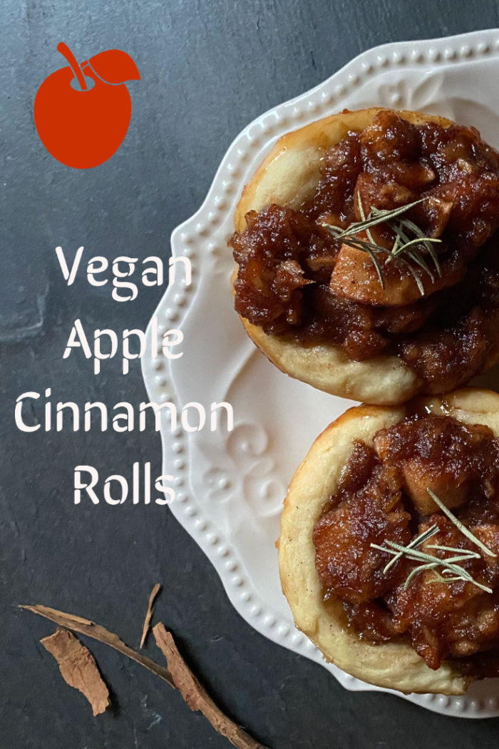 vegan apple cinnamon rolls on a white plate with caption
