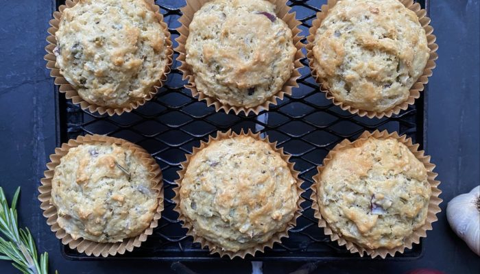 Vegan red onion rosemary muffins on a black cooling rack