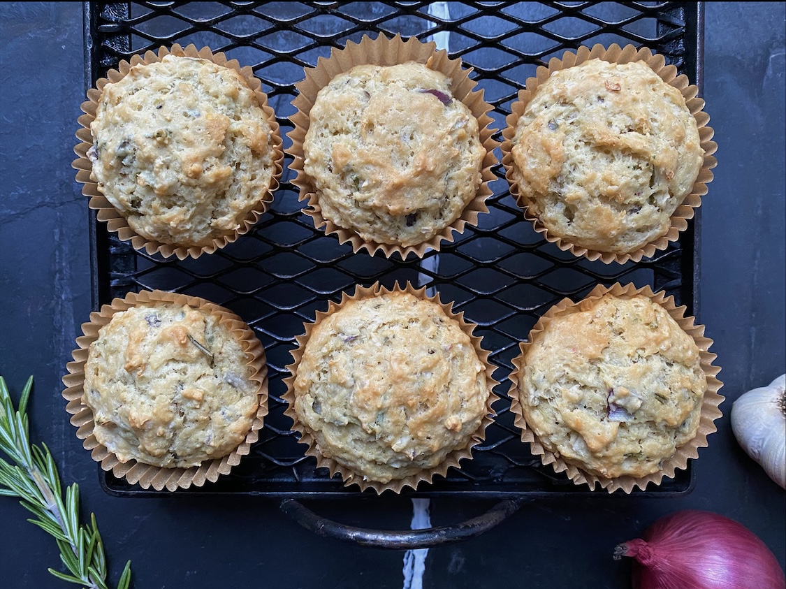 Vegan red onion rosemary muffins on a black cooling rack