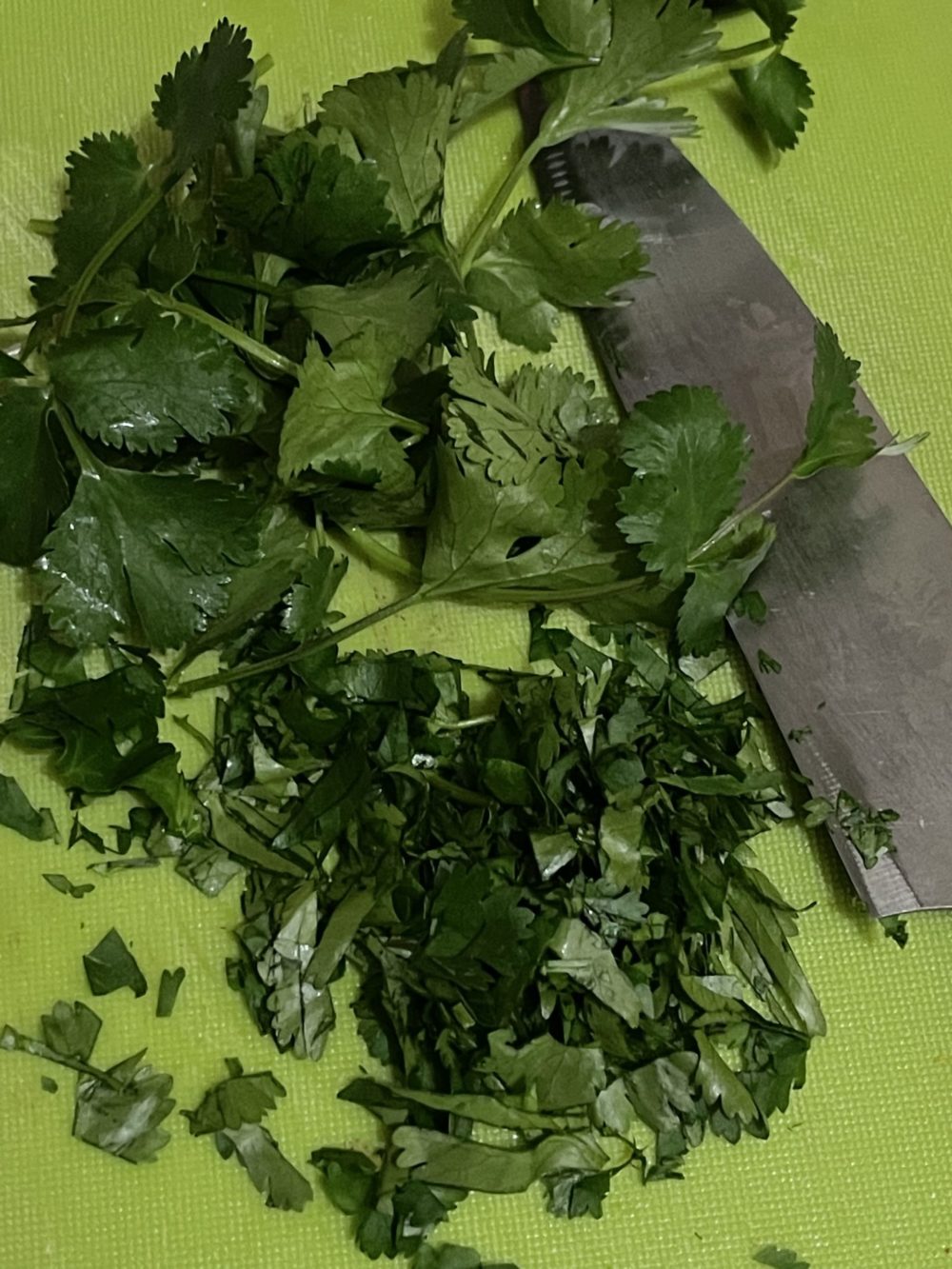 Chopped parsley and knife on a green background