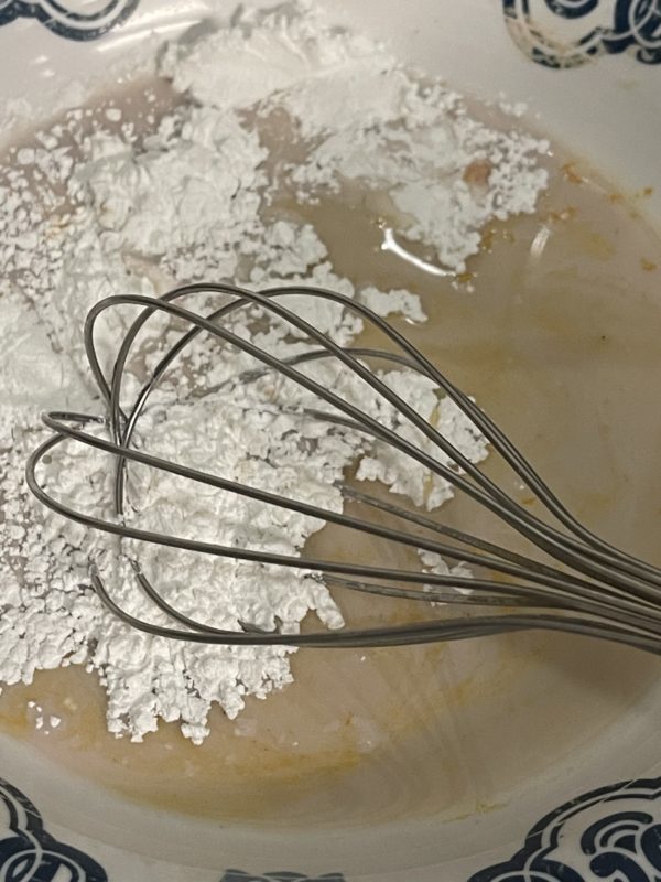 A mixture in a bowl with a whisk