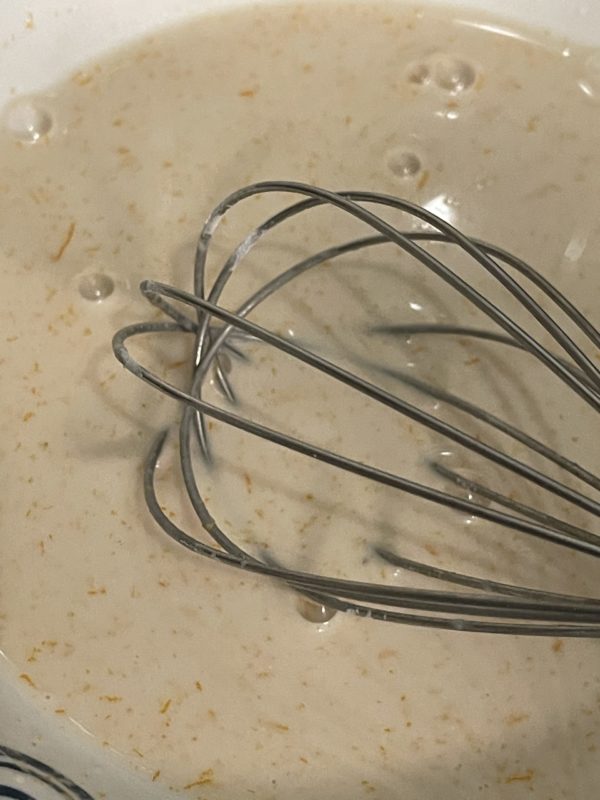 Liquid mixture in a bowl with a whisk