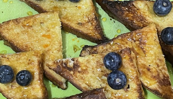 Vegan french toast with berries on a green plate