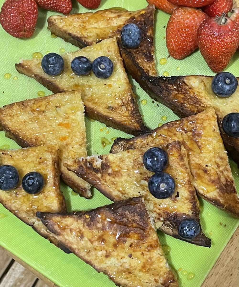 Vegan french toast with berries on a green plate