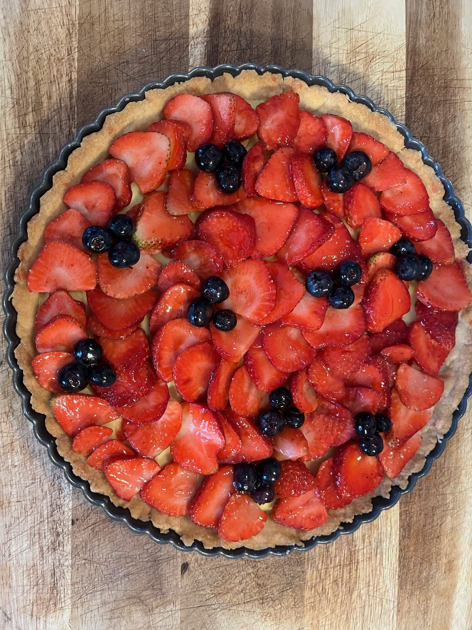 Vegan fruit tart against a brown background