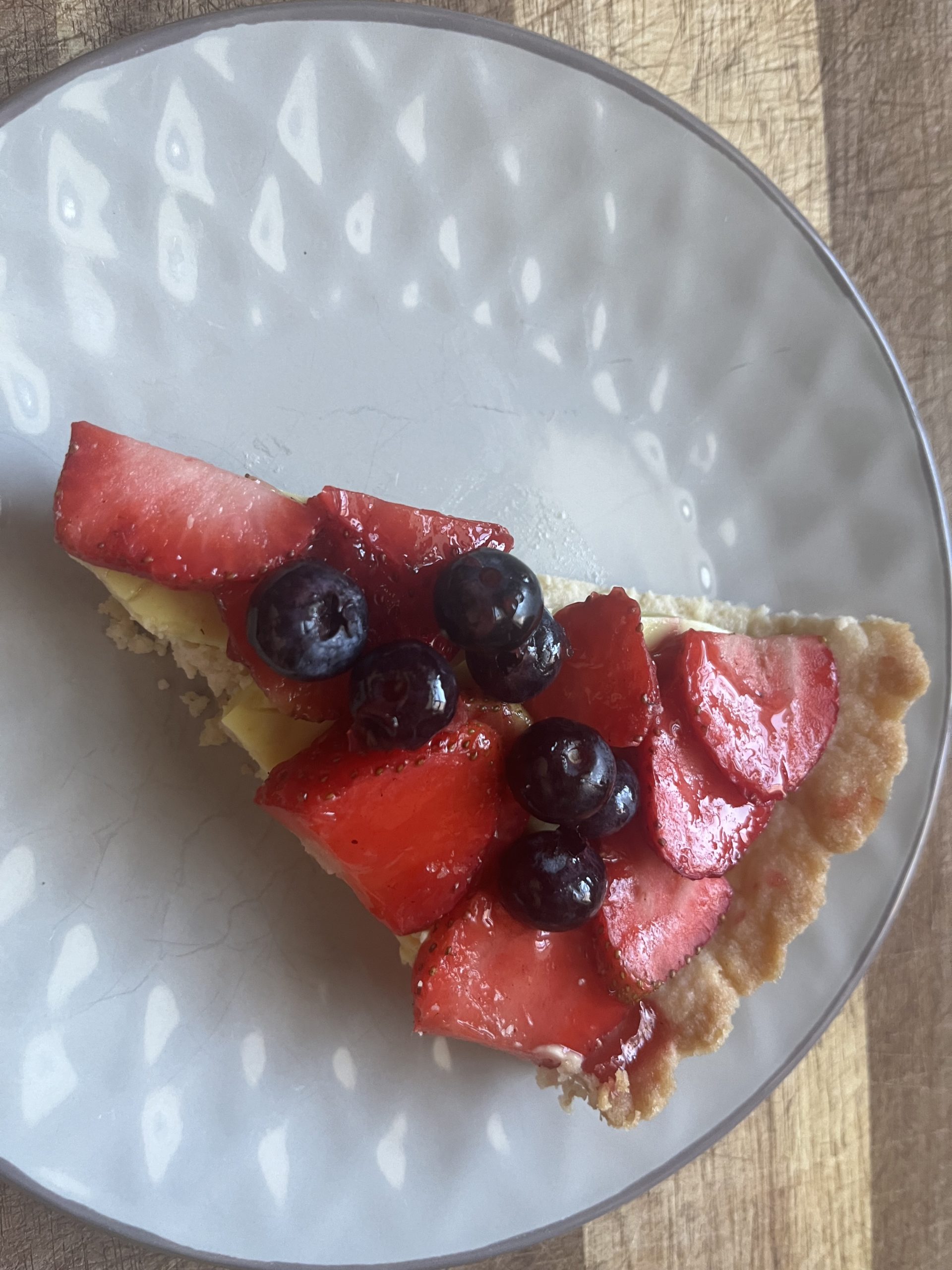 A slice of vegan fruit tart on a white plate