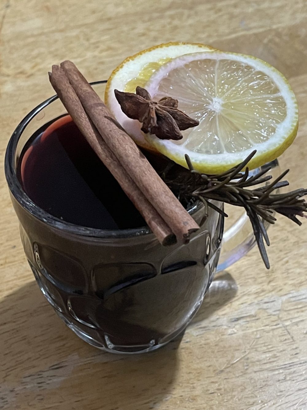 a glass of spiced hibiscus tea with lemon and cinnamon sticks