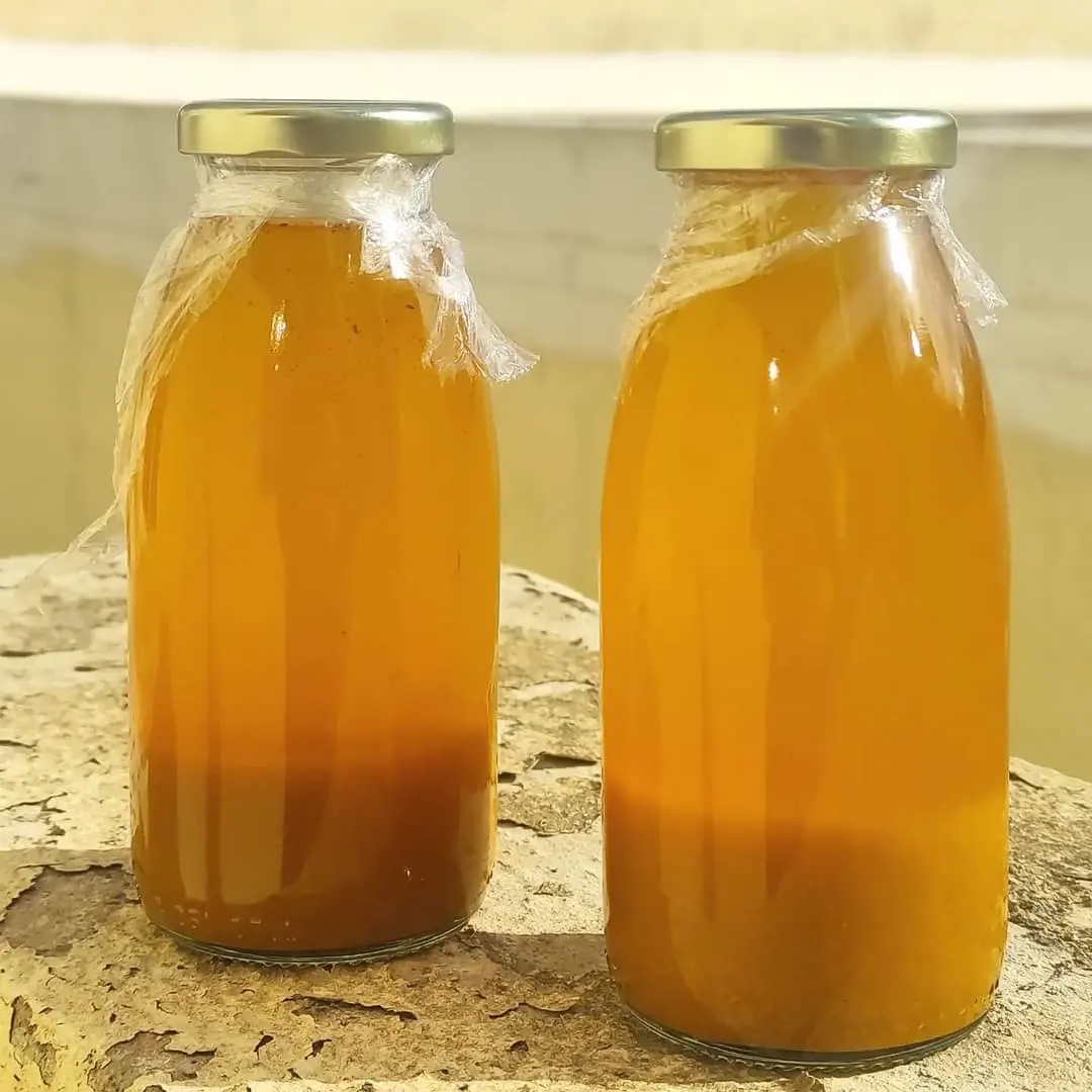 Two orange bottles of fire cider with silver lids